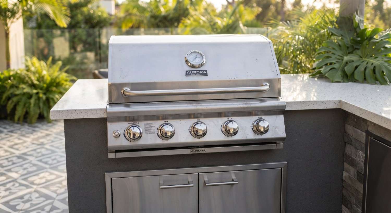 Built-in grill seated in a stone outdoor kitchen counter