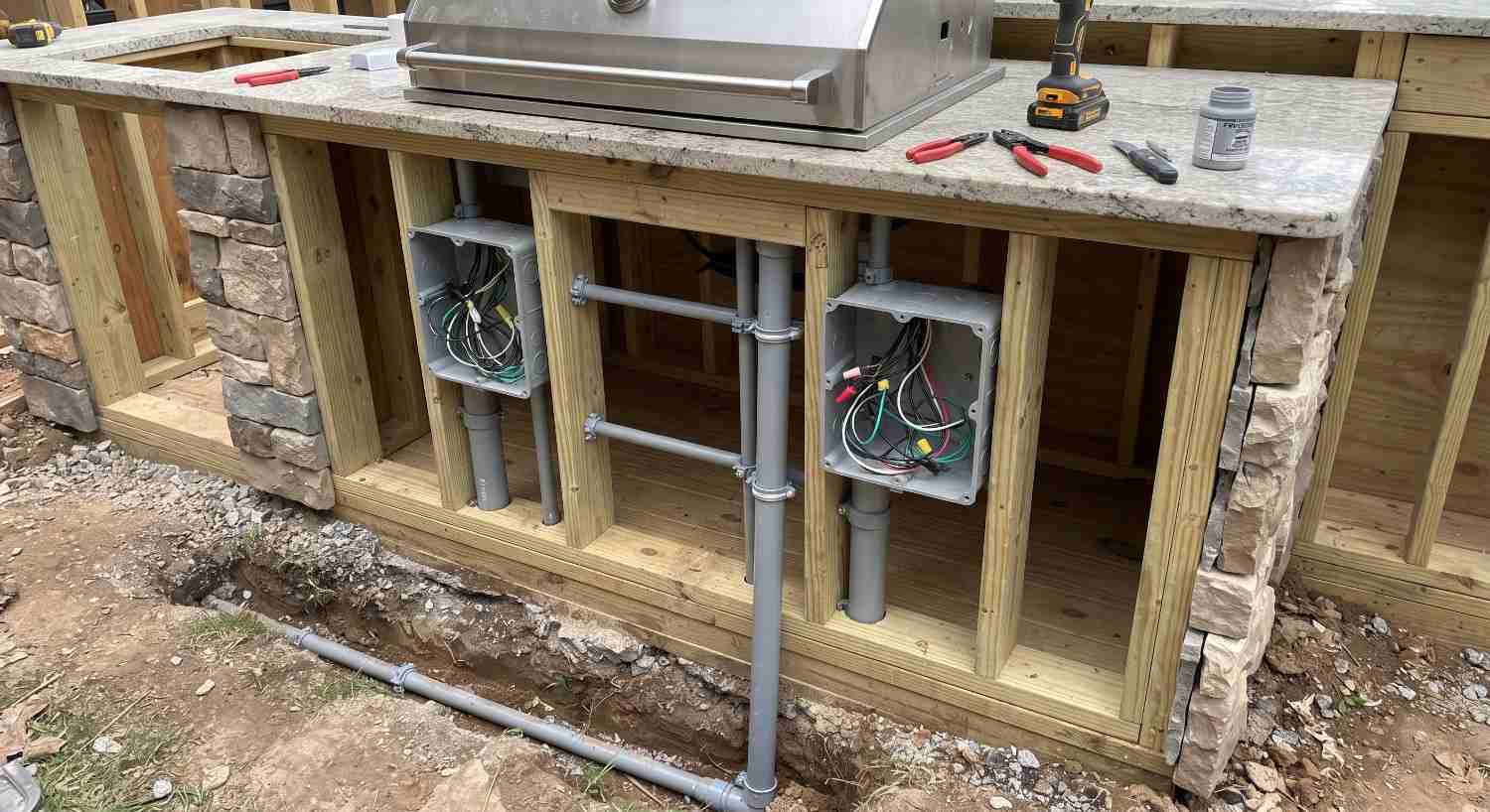 Services running through an outdoor kitchen frame before the cladding is fitted